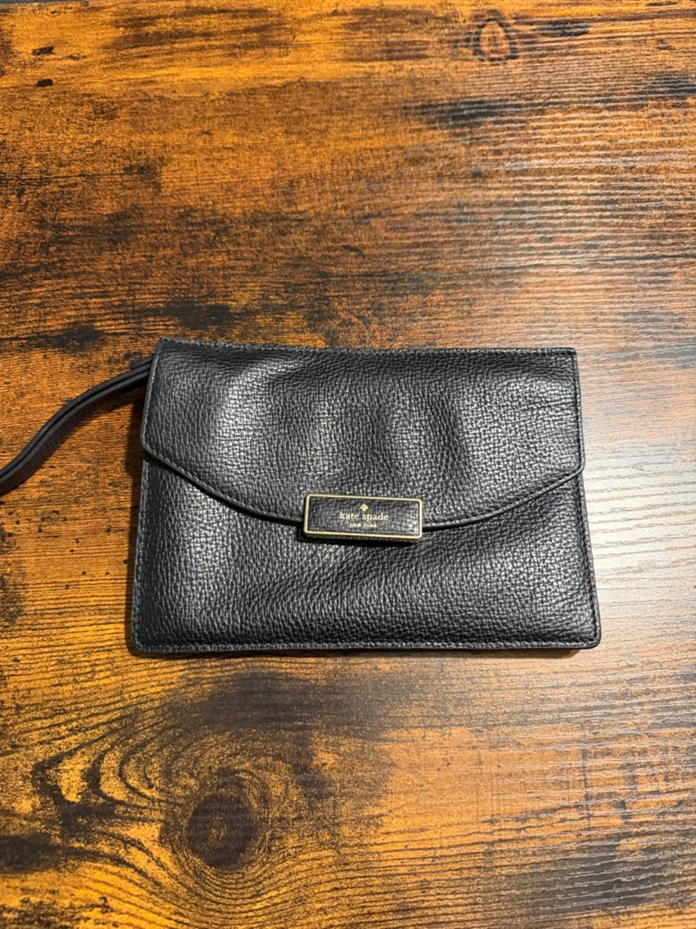 kate spade black pebbled leather wristlet with gold logo plaque